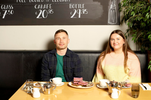 Two people eating traybakes